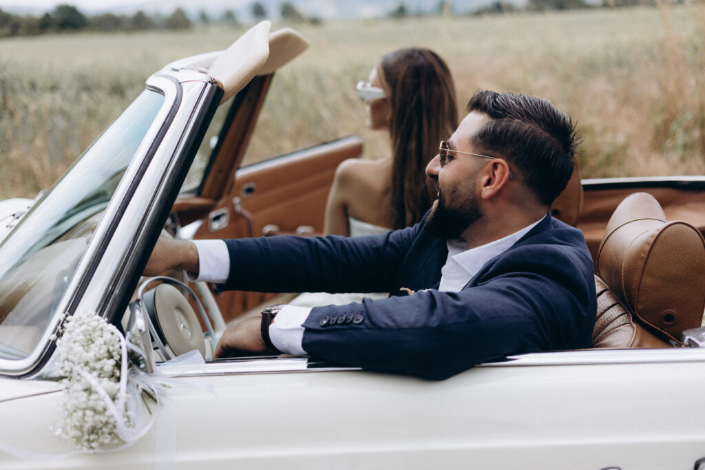 Just Married: The Journey Begins Groom driving a vintage convertible, smiling, with the bride in the passenger seat.<br />