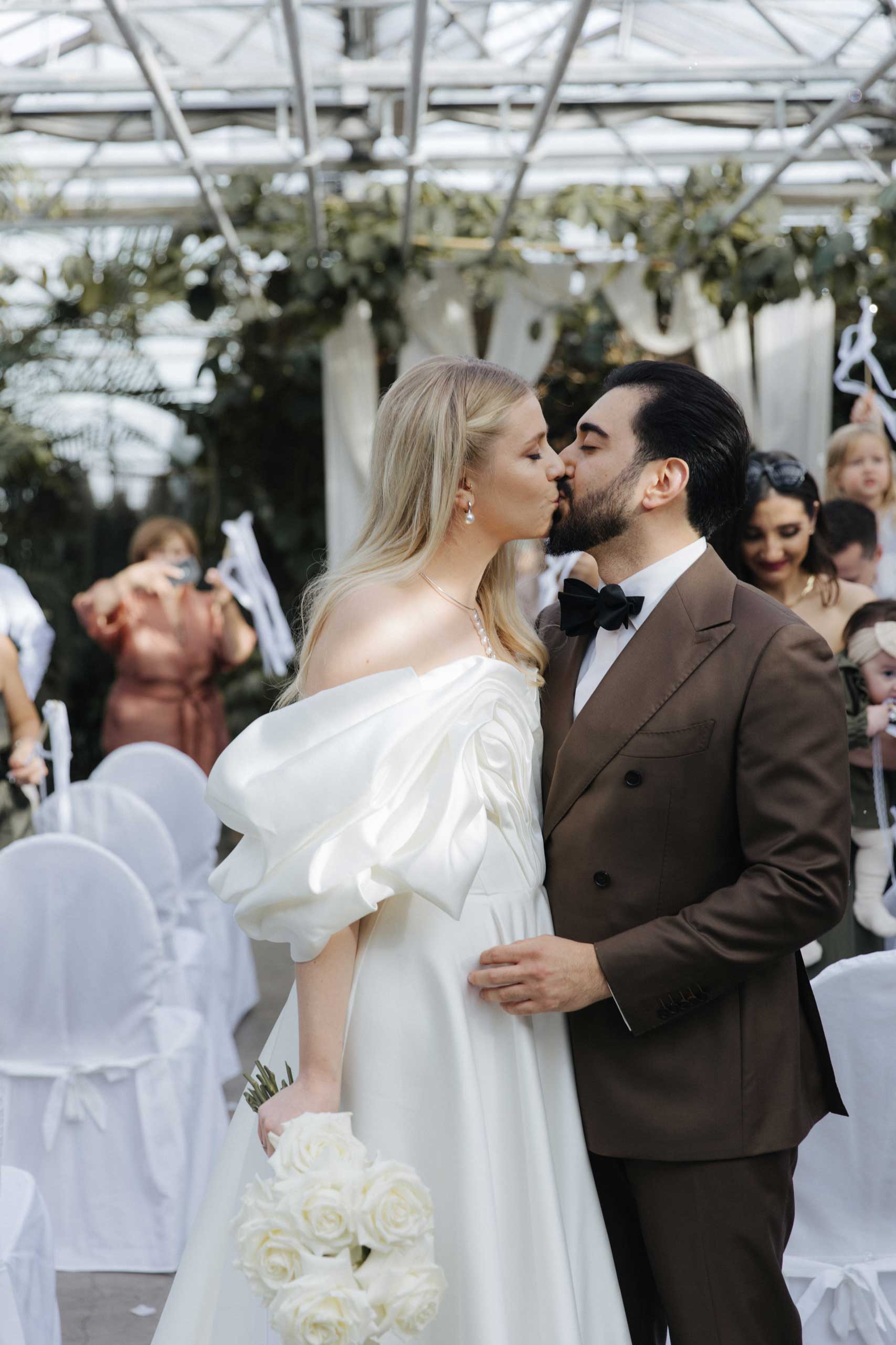 stuttgart-photographer-kulyzka Couple dancing joyfully in the street, dressed in modern white outfits with pink heels and sneakers.<br />